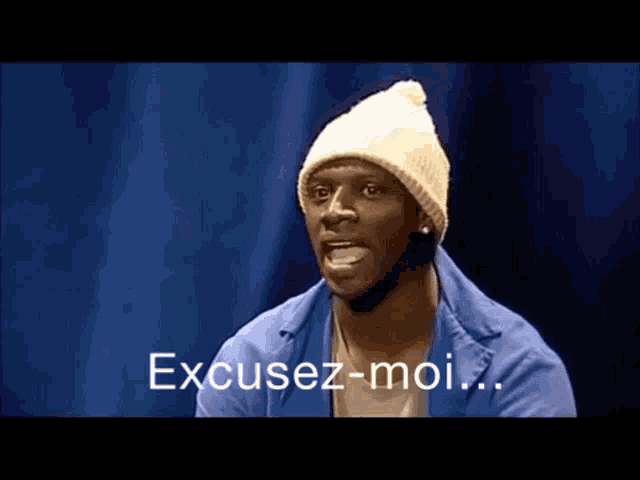 a man wearing a white beanie and a blue jacket says excusez-moi
