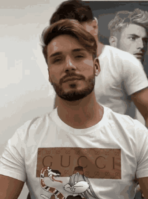 a man with a beard wears a gucci t-shirt