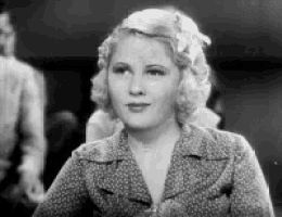a black and white photo of a woman wearing a polka dot jacket .