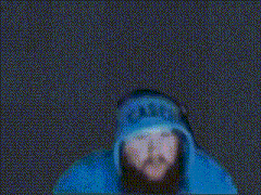 a blurry picture of a person in a blue jacket with a black background