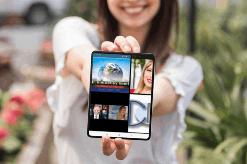 a woman holds up a cell phone that says jr. kimberly linert on the screen