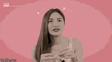 a woman is holding a piece of paper in front of her face with question marks above her head ..