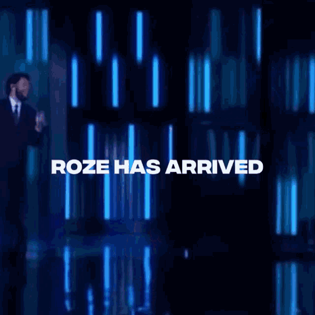 a woman singing on stage with the words " roze has arrived " behind her