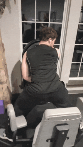 a man in a black shirt is standing on a machine