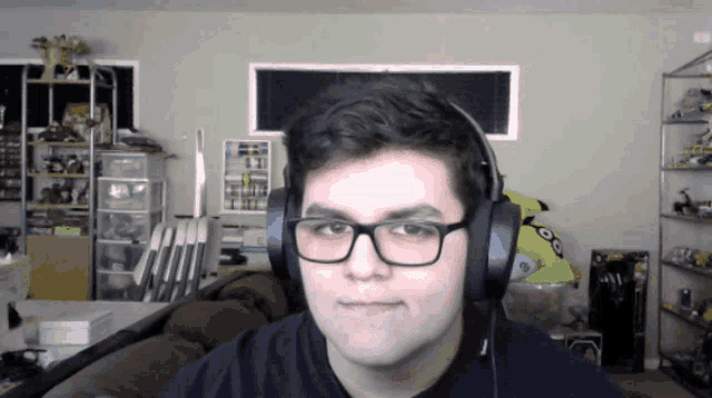 a young man wearing glasses and headphones is looking at the camera