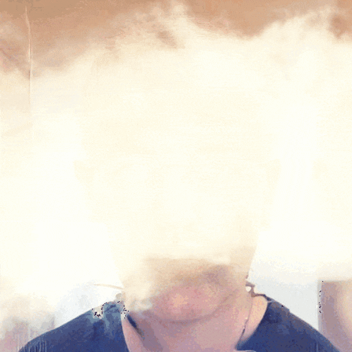 a man 's face is surrounded by clouds and smoke