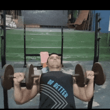 a man is lifting dumbbells on a bench and his shirt says do better