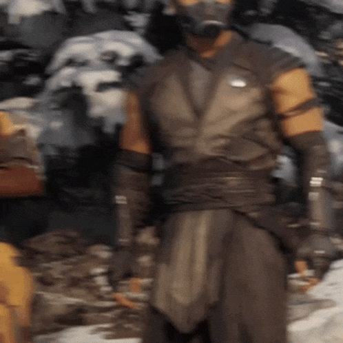 a man is wearing a mask and gloves while standing in the snow .