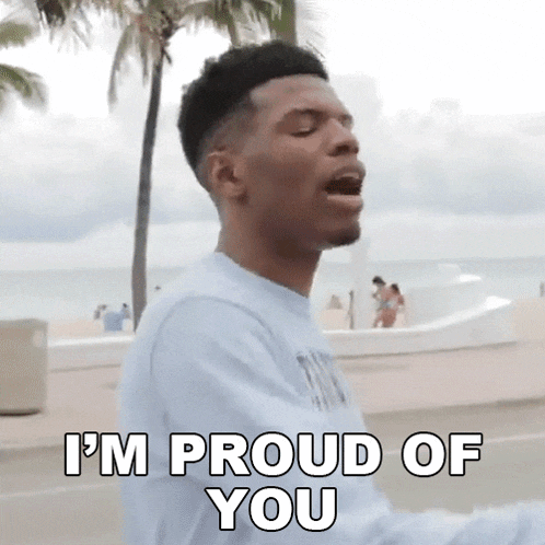 a man is standing in front of a palm tree and says i 'm proud of you