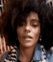 a woman with a nose ring is wearing a denim jacket .