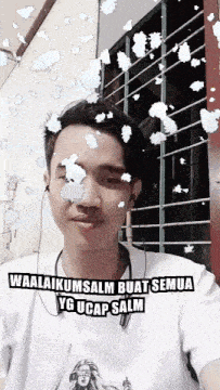 a man wearing ear buds and a shirt that says waalaikumsalm buat semua yg ucap salm