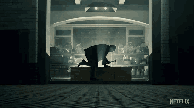 a man is kneeling down in front of a netflix logo