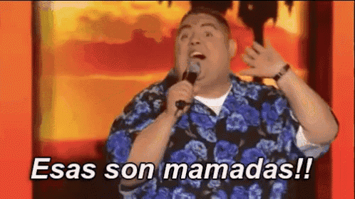 a man is singing into a microphone with the words " esas son mamadas " written below him