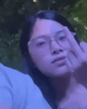 a woman wearing glasses is making a middle finger sign .