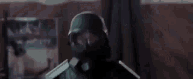 a man wearing a helmet and goggles is standing in a dark room .