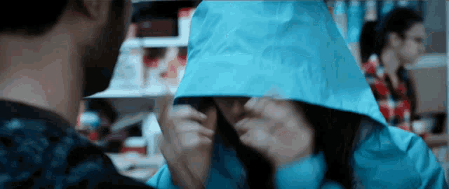 a woman wearing a blue jacket with a hood on her head