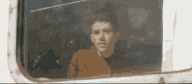 a man is looking out of a window of a vehicle .