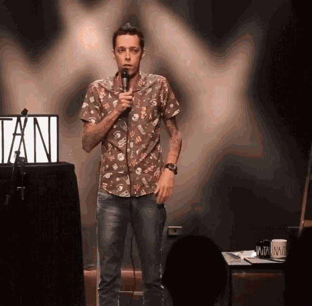 a man stands in front of a sign that says tan on it