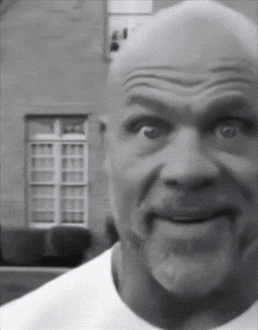 a black and white photo of a bald man with a beard making a funny face