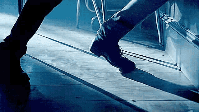 a person 's foot is standing on a tile floor