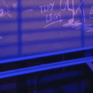 a cartoon dog wearing a hat and a blue sweater is standing in front of a chalkboard that says tiny