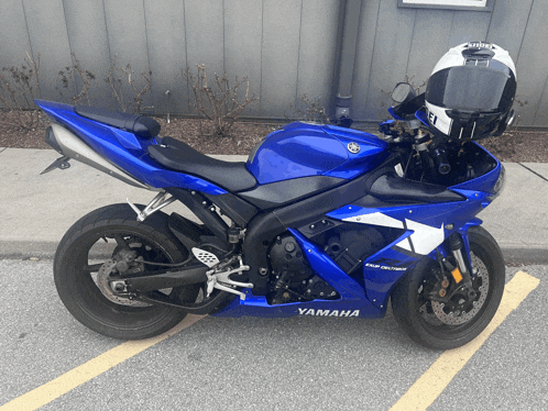a blue and white yamaha motorcycle is parked in a parking lot