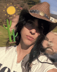 a woman wearing a cowboy hat with a cactus on her shoulder