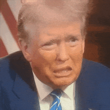 a close up of donald trump 's face with his hair blowing in the wind