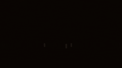 a white cat is sitting in a dark room