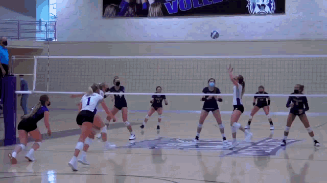 a volleyball game is being played in front of a banner that says voll