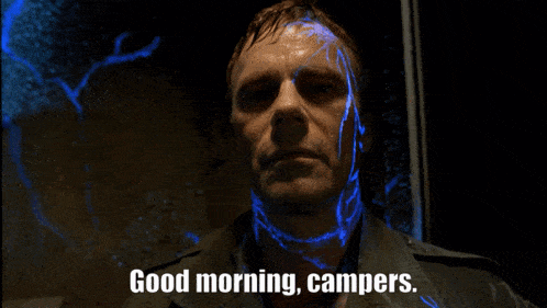 a man says good morning campers in front of a blue background