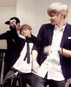 a man in a suit and tie is dancing with another man in a hat .