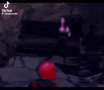 a man in a red shirt is holding a woman in a black dress in a dark room .