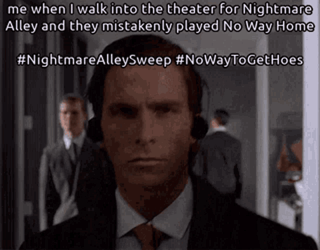 a man in a suit and tie is wearing headphones while walking into a theater
