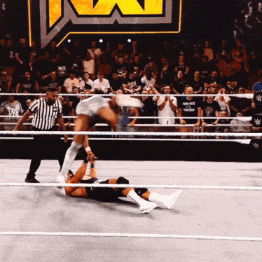 a wrestling match is being watched by a crowd and the hashtag tiffanyluv24 is on the bottom right