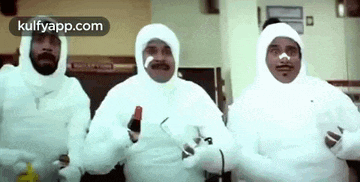 a group of men wearing white suits are standing next to each other in a kitchen .