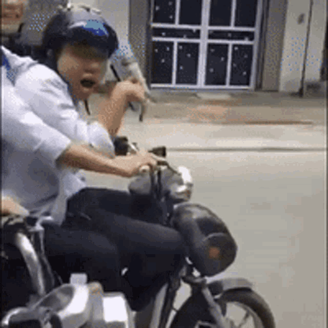 a man wearing a helmet is riding a motorcycle on the street .