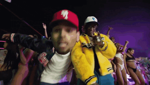 a man wearing a la hat is standing next to another man in a yellow jacket