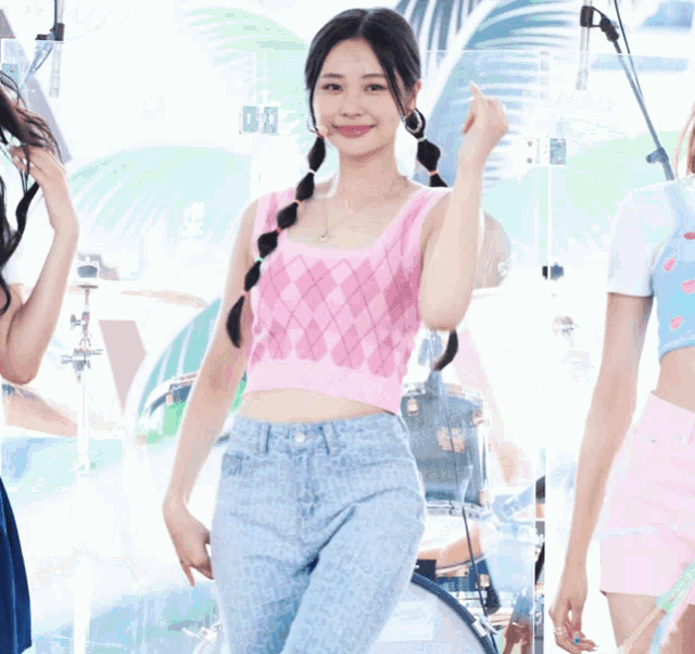 a woman in a pink tank top and blue shorts smiles