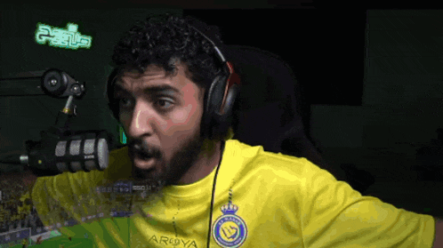 a man wearing headphones and a yellow shirt that says argoya on it