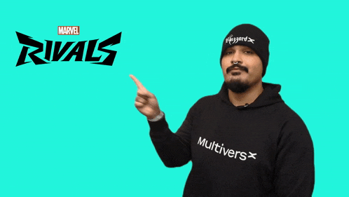 a man wearing a black hoodie and a black beanie is pointing to the marvel rivals logo