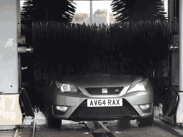 a car with a license plate that says av64 rax is in a car wash