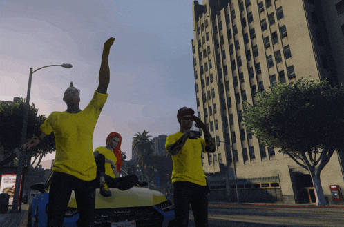 three people wearing yellow shirts are standing in front of a blue audi