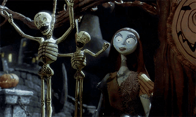 a couple of skeletons hanging from a tree with a cross on their heads