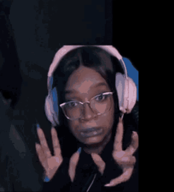 a woman wearing headphones and glasses is making a funny face .