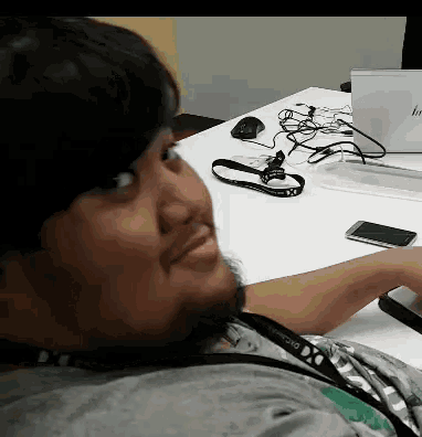 a man sitting at a desk with a lanyard around his neck that says dx