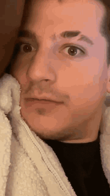 a close up of a man 's face with a black shirt