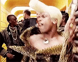 a woman in a leopard print dress is standing in a crowd .
