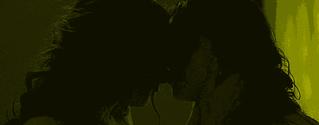 two women are kissing in a dark room