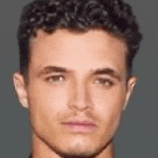 a close up of a man 's face with curly hair looking at the camera .